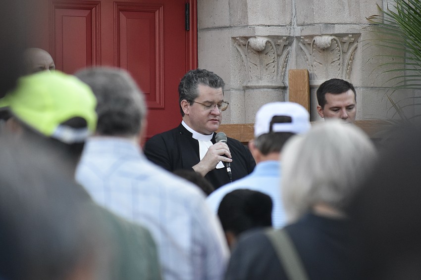 Rev. Charleston Wilson, rector of Church of the Redeemer, speaks at the church, the final station.