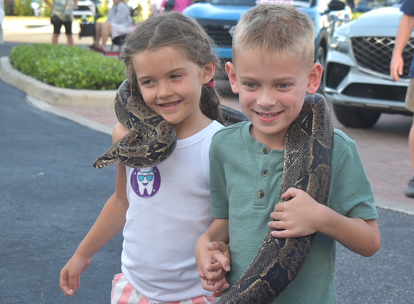 Parrish's Ava Corriveau, 5, and Lakewood Ranch's Grayson Watts, 6, hold a 14-year-old boa constrictor from Bugz Rule.