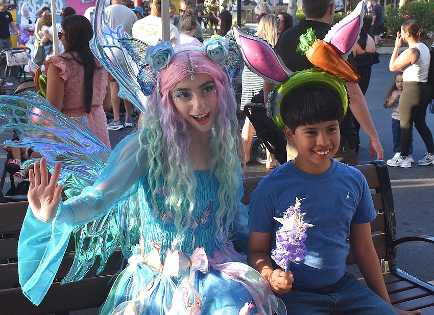 The Butterfly Fairy, who escorted the Easter Bunny to Music on Main, spends a moment with Bradenton 9-year-old Oliver Estrada after giving him bunny ears.