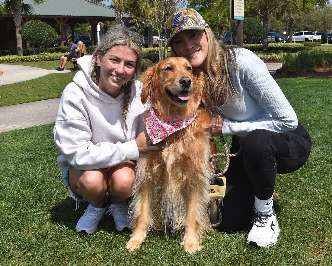 Angelina Goesch and her mom, Ana Goesch, founder of Dogs of Lakewood Ranch, pose with Ana's 4-year-old Golden retriever, Maple.