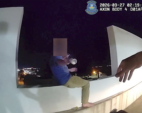 Screenshot of a body-worn camera video shows the moment SPD Officer Michal Banasiak reaches for a bottle before grabbing the man in distress and pulling him to safety.and