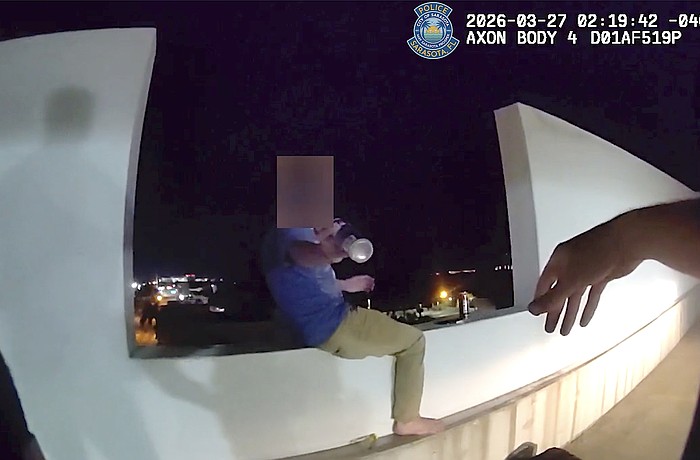 Screenshot of a body-worn camera video shows the moment SPD Officer Michal Banasiak reaches for a bottle before grabbing the man in distress and pulling him to safety.and