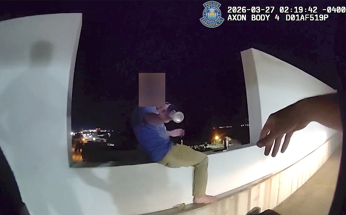 Screenshot of a body-worn camera video shows the moment SPD Officer Michal Banasiak reaches for a bottle before grabbing the man in distress and pulling him to safety.and