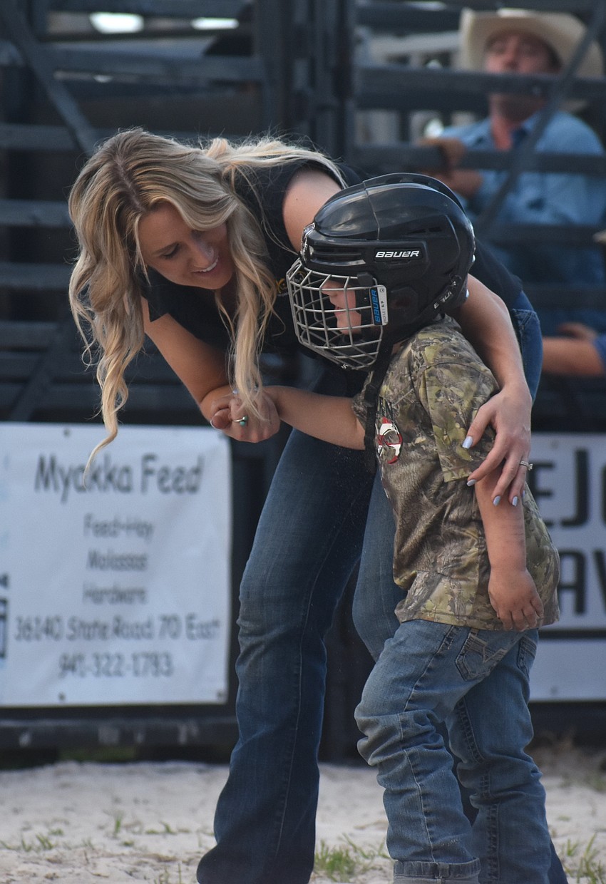 Jenny Dakin and her son Truett, 4, walk away after Truett participated in mutton busting.