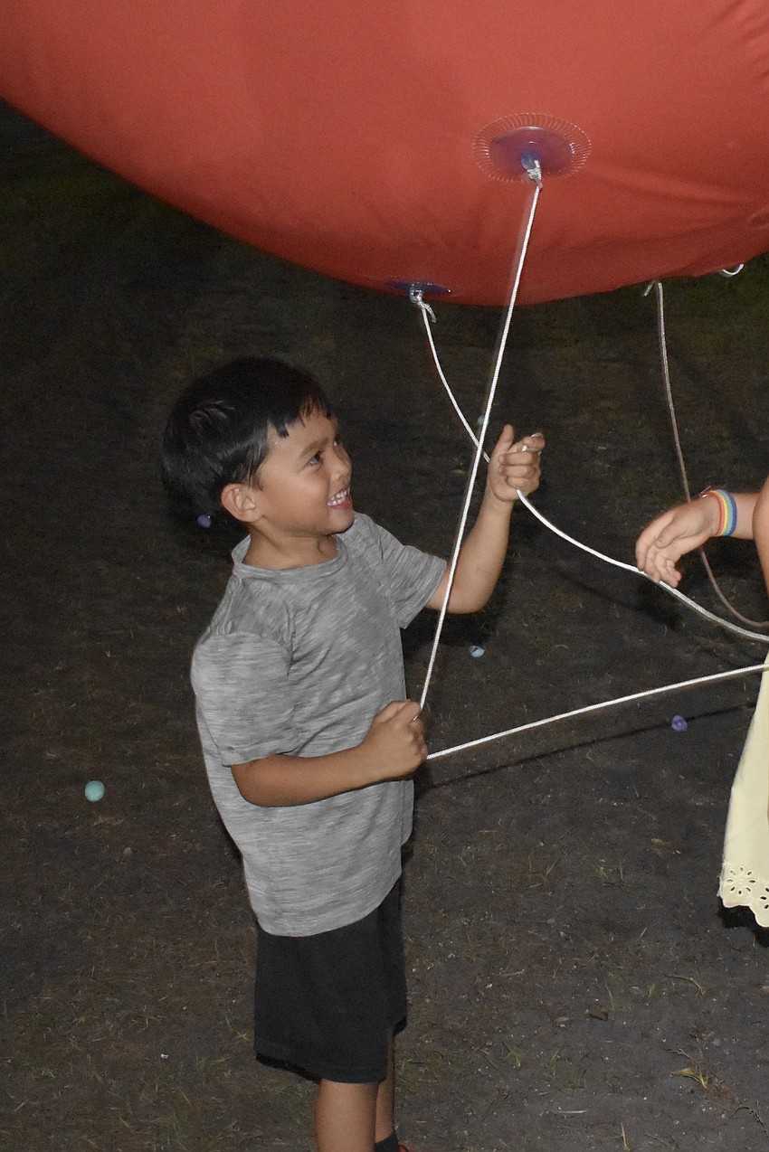 Brady Byrd, 4, plays with a large balloon on display.