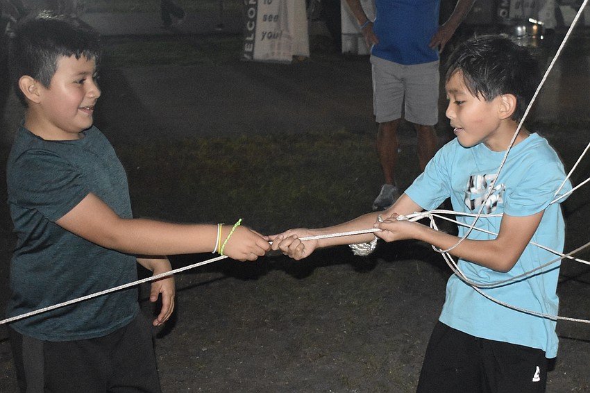 Matthew Tafolla, 7, and Brandon Byrd, 8, play with a string attached to a large balloon on display.