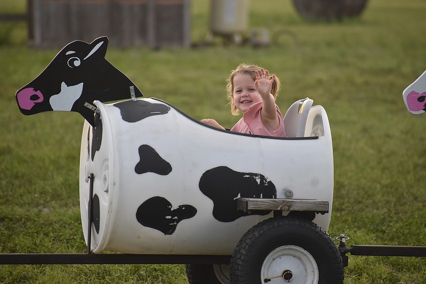 St. Petersburg's Rylynn Rowe, 3, greets her family members as she rides past at Dakin Dairy Farms.
