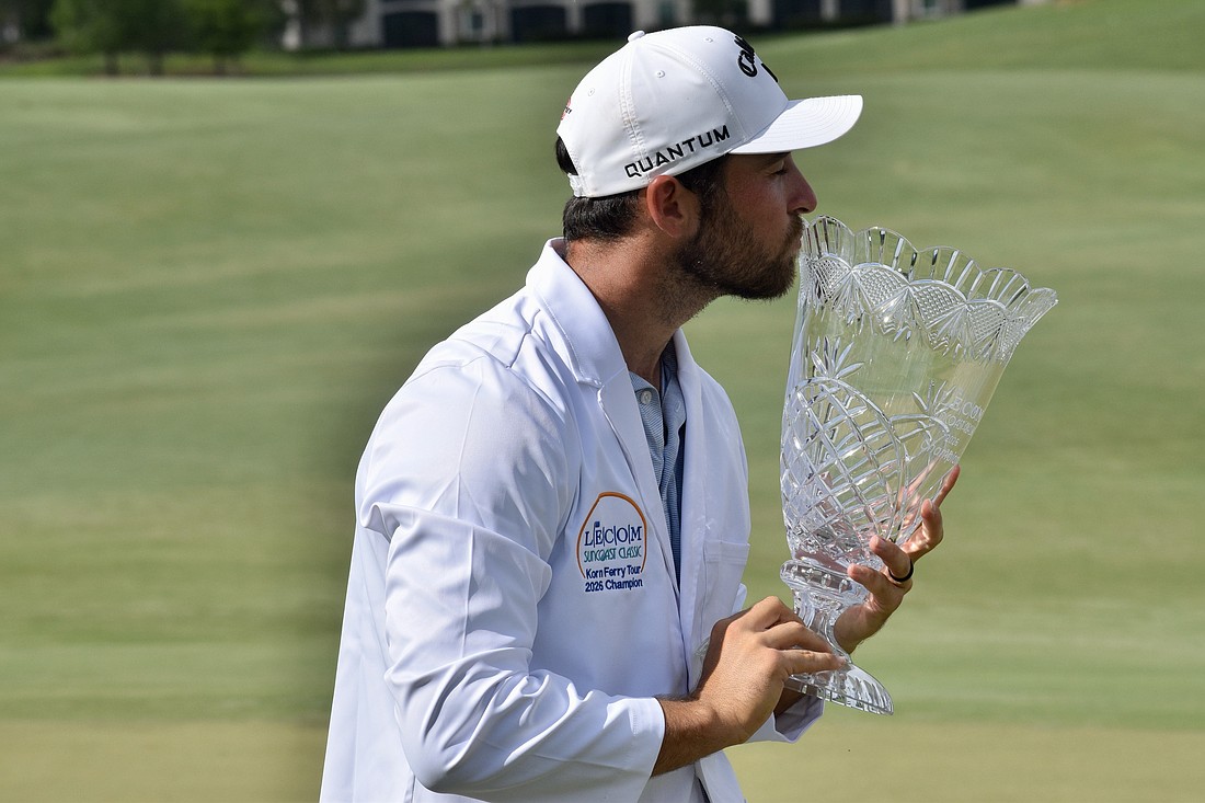 Jeremy Gandon kisses the LECOM Suncoast Classic trophy. He shot six under par in the final round to win the title at 22 under par overall, defeating Mitchell Meissner and Jay Card III by one stroke.