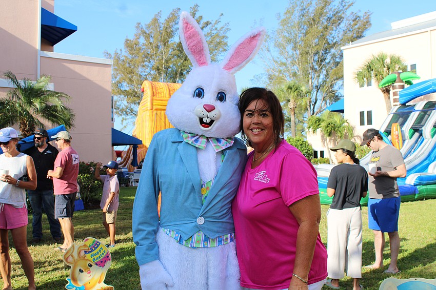Organizer Heather Diggins and the Easter Bunny take in the fun of the families enjoying the Easter egg hunt at Sand Cay.