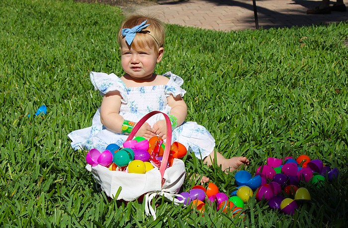 Emi Frydman checks out the basket of Easter eggs her family members found at the April 4 egg hunt at St. Armands Key Lutheran Church. The Easter activities, open to the public, made their return for the first time since the early 2020s through the efforts of church members.