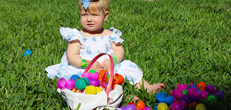 Emi Frydman checks out the basket of Easter eggs her family members found at the April 4 egg hunt at St. Armands Key Lutheran Church. The Easter activities, open to the public, made their return for the first time since the early 2020s through the efforts of church members.