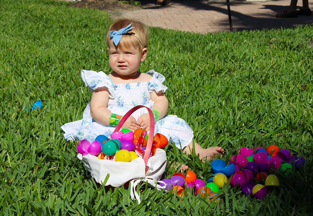Emi Frydman checks out the basket of Easter eggs her family members found at the April 4 egg hunt at St. Armands Key Lutheran Church. The Easter activities, open to the public, made their return for the first time since the early 2020s through the efforts of church members.