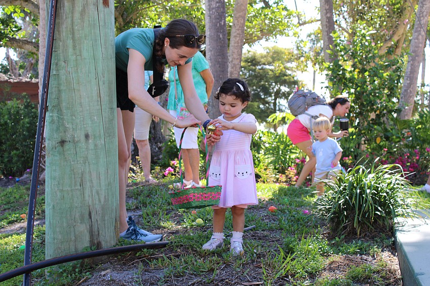 Mia Kober finds a golden egg hidden in the corner of the Meditation Garden at St. Armands Key Lutheran Church.