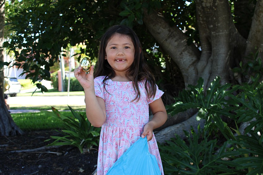 Haruki Warriner, who was visiting Joan Nelson and other family for Easter, finds one of the golden eggs at the St. Armands Key Lutheran Church Easter egg hunt.