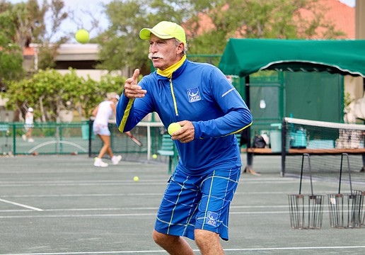 Longboat Key Tennis Center pro Robbie Salum tosses a tennis ball up for warm-ups at a clinic on April 8. He and his fellow pros shared what they find special about the public courts and insight into the career paths that led them there.