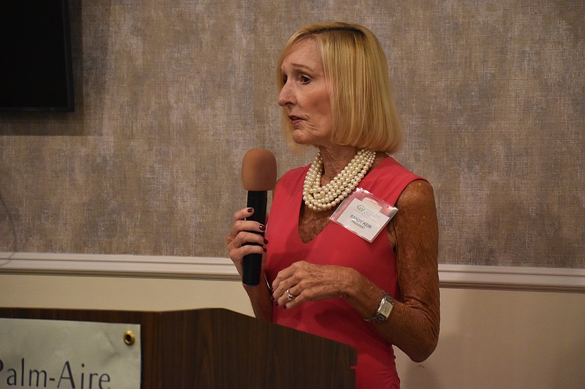 Sandy Keir, president of the Palm Aire Women's Club, welcomes members and scholarship recipients to the luncheon April 10.