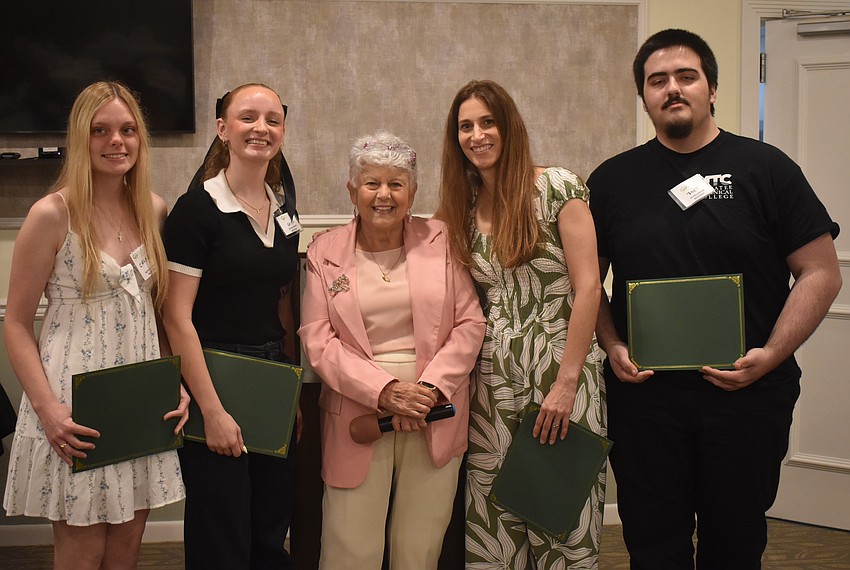 Scholarship recipients Chloe Jarvis, Sara Sweetnich, Victoria Bigham and Bart Reek gather around Scholarship Chair Carol McManus after they each said a few words to the audience.