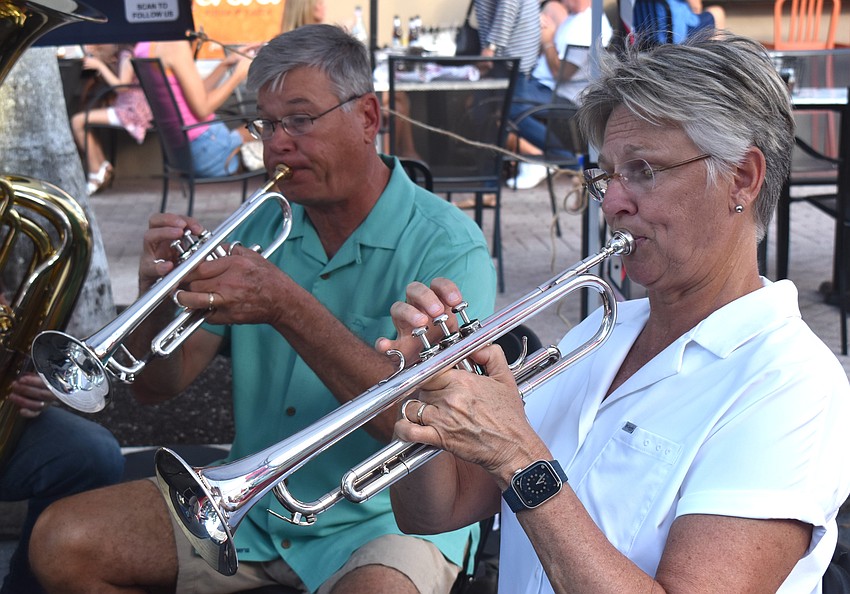 Gene Bohland and Julie Waters play trumpet at the Lakewood Ranch Wind Ensemble booth at the Lakewood Ranch Block Party April 10.