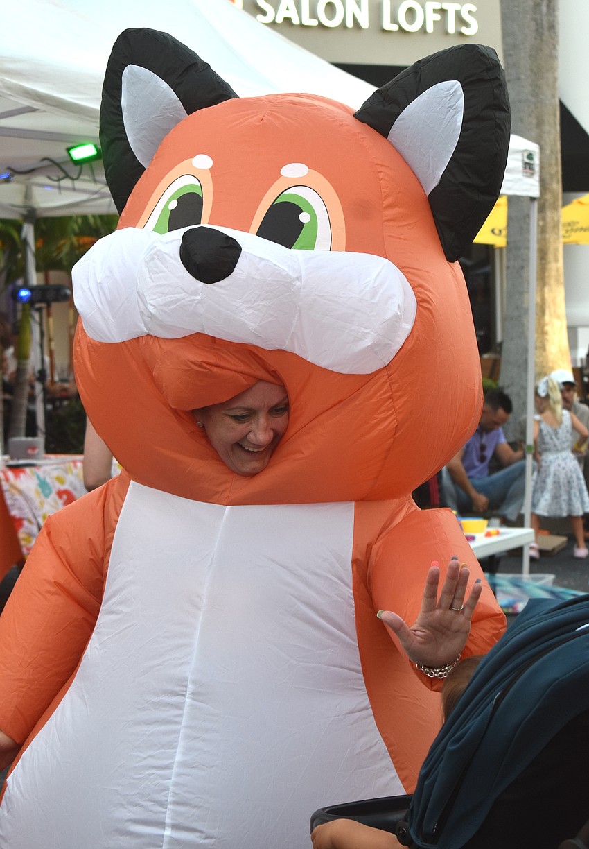 Laurie McCracken, owner and executive director of Baby Fox Academy, greets a child while dressed as a fox at the Lakewood Ranch Block Party.