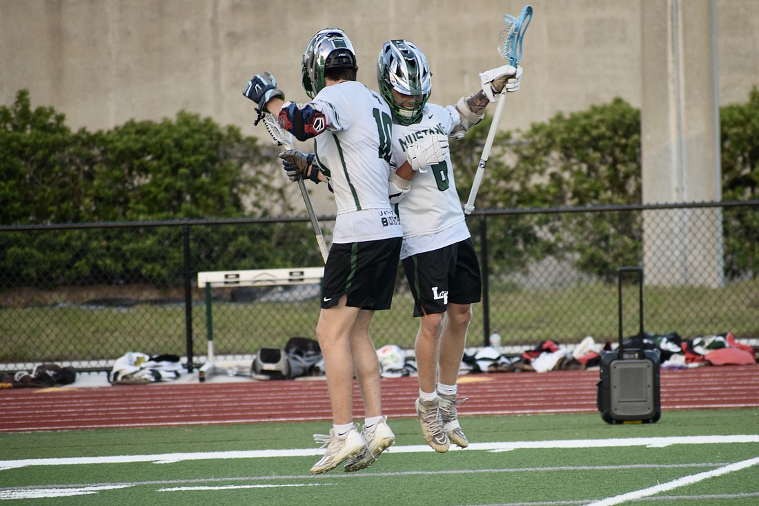 Junior Jackson Zackery (left) celebrates with senior Peyton Hens (right) after a goal against Sarasota High on April 9 in the FHSAA Class 2A-District 12 quarterfinals. Lakewood Ranch advanced with a 13-4 victory.