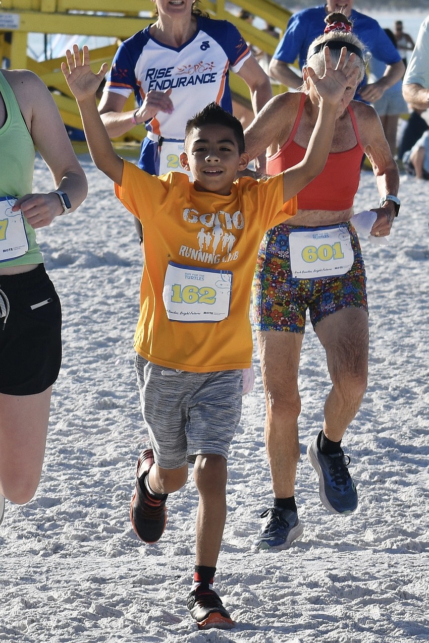 Damian Najera, 9, of the Gocio Elementary School Runners Club arrives at the finish line.