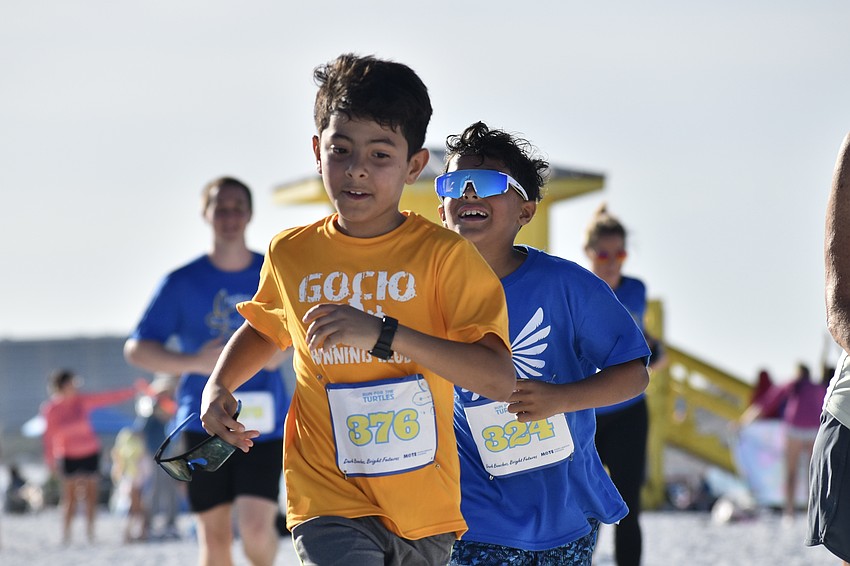 Nestor Urbina and Adrian Lobo, third graders from the Gocio Elementary School Runners Club, approach the finish line.