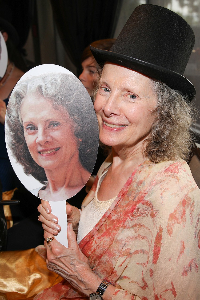 Stephanie Sundine holds a stick-head in her likeness during dinner. Her husband, Victor DeRenzi, is completing his last with the Sarasota Opera.