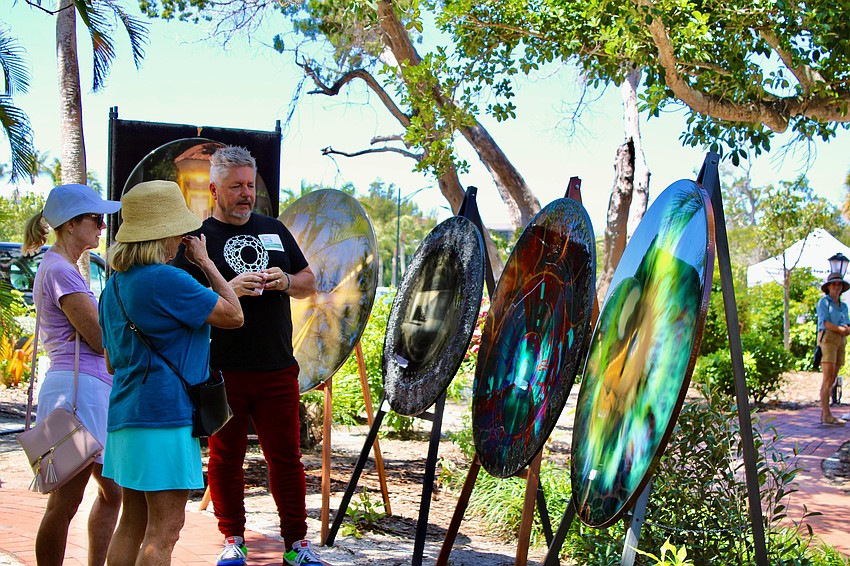 Artist Collin Rowland discusses his works with visitors to Artists in the Garden.