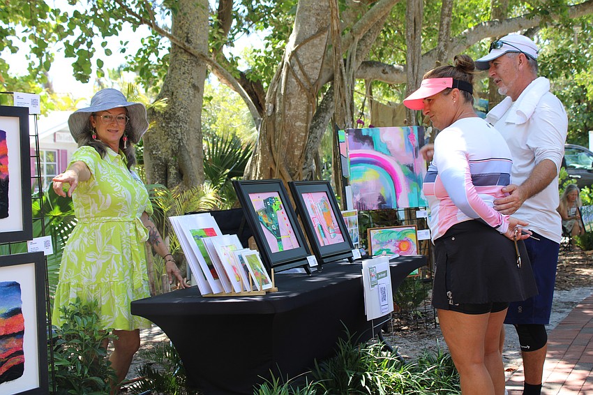 Artist Jen Kroeger chats with patrons Jacqueline Russell and Laszlo Sikora, who bought a piece from another local creative at last year's Artists in the Garden. They said they were pleased to see the event return for a second year.