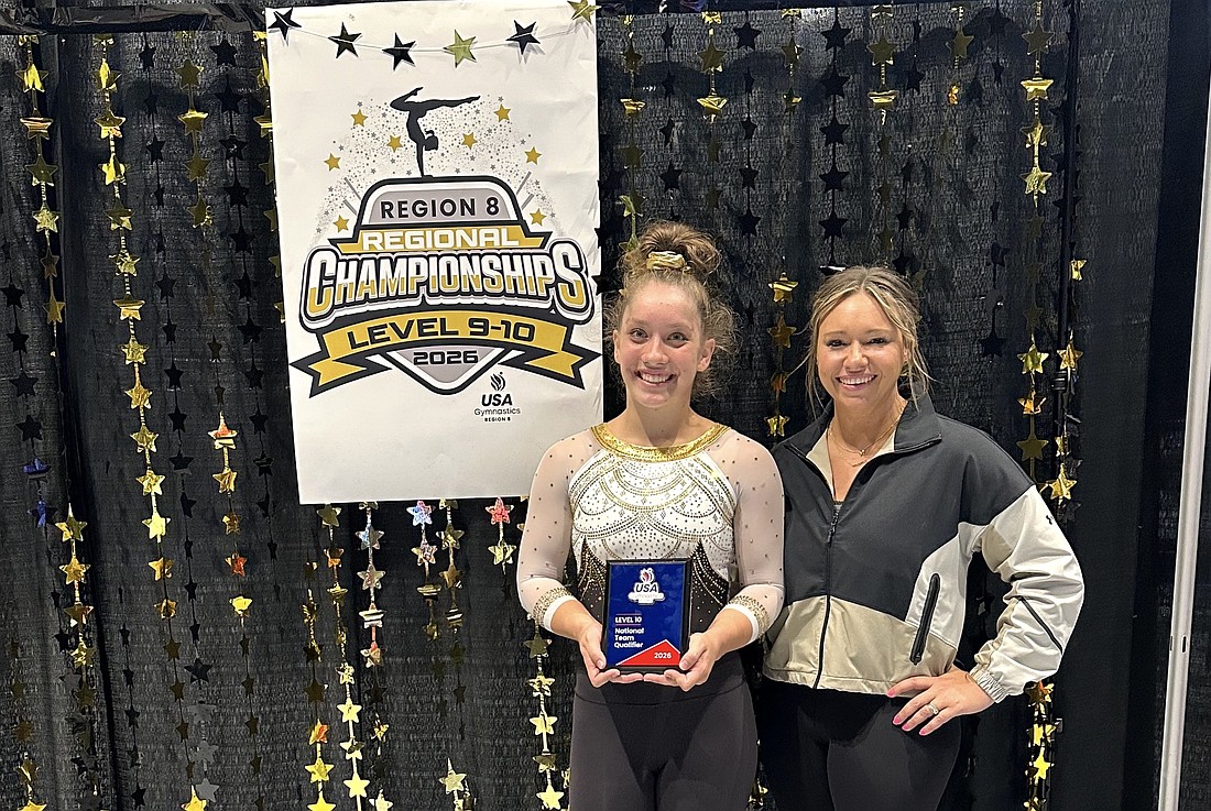Anna Schwartz, with Palm Coast Gymnastics owner/coach Kelly Flagler, holds up the plaque designating her as a National Team qualifier. Courtesy photo