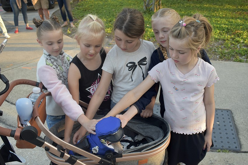 Olivia Silva, 7, Stevie Aldrich, 8, Harper Rossnagle, 8, Kendall Silva, 9, and Hailey Rossnagle, 6, pet Dolly, who came dressed as a police officer.