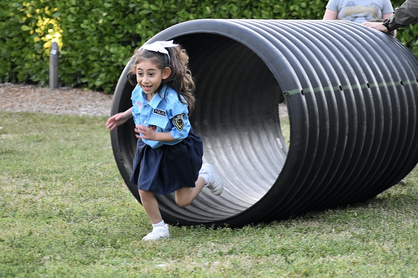 Mia Martinez, 6, emerges from a tunnel in the obstacle course.