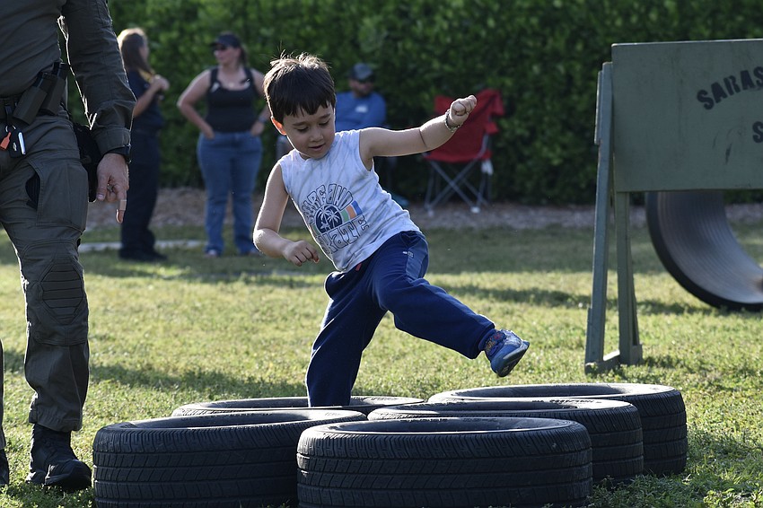 Liam Kai, 5, steps through a row of tires in the obstacle course.