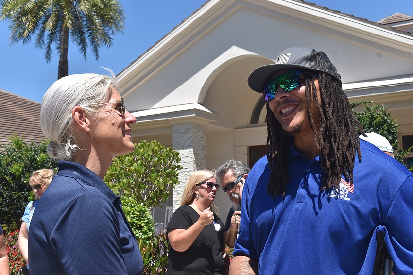 Elizabeth Evans Weiss, the founder of Elizabeth Evans Custom Homes and builder of the Homes for Our Troops homes, greets home recipient Eddie Ward.