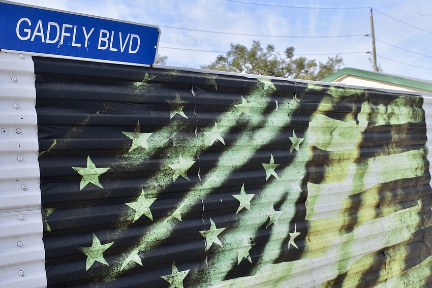 A sign for Gadfly Boulevard is prominently placed in Glen Gibellina's driveway. The fence was made from a salvaged shipping container.