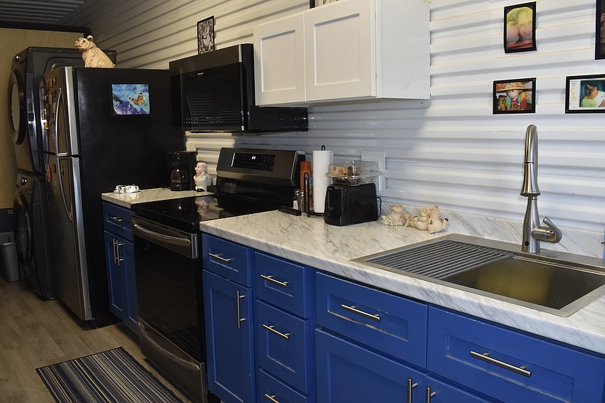 The tiny house has a full kitchen and a stackable washer and dryer set.