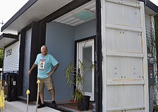 Glen Gibellina stands at the entrance of a tiny house he built using a shipping container.