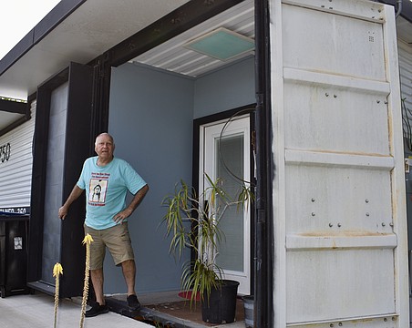 Glen Gibellina stands at the entrance of a tiny house he built using a shipping container.