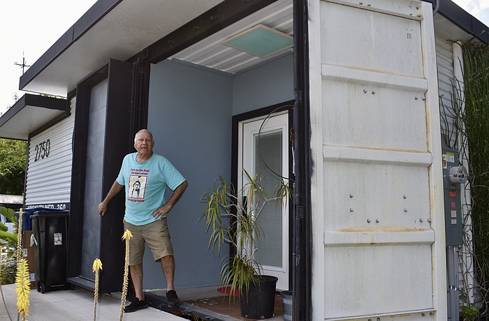 Glen Gibellina stands at the entrance of a tiny house he built using a shipping container.