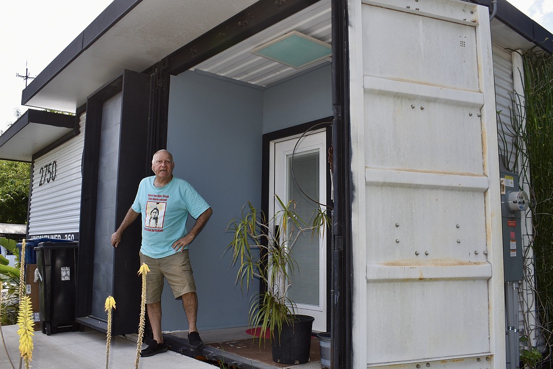 Glen Gibellina stands at the entrance of a tiny house he built using a shipping container.