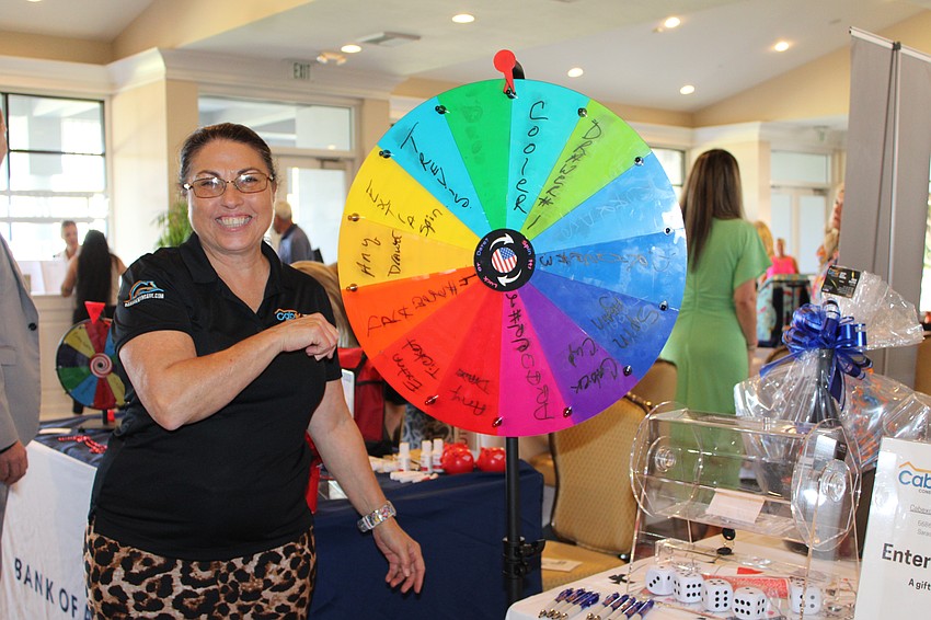 Representing Cabex Construction, Debbie Shaffer gives the prize wheel a spin at the company's booth at the 20th annual Meet Greet Eat social.