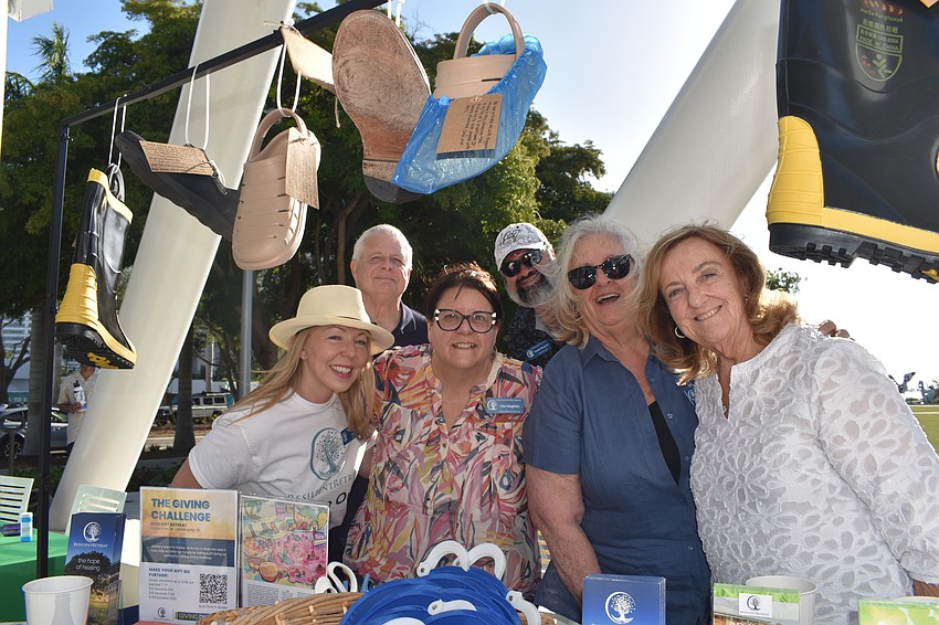 Lauren Luke, Robert Dalton, Lisa Intagliata, Ramin Mesghali, Carla Malachowski and Bonnie McIntyre staff the Resilient Retreat table. The shoes on display, with personal notes attached, represent that trauma comes from all walks of life.