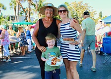 Margarita Lenk, Ari and Stephanie Weiner pick out their slices at the Longboat Harbour annual farewell pizza party on April 16.