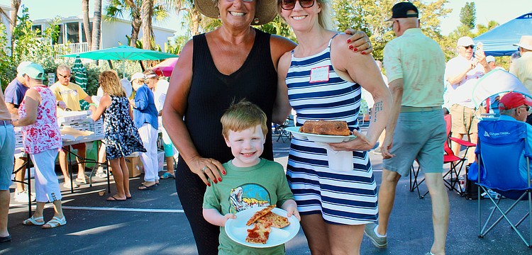 Margarita Lenk, Ari and Stephanie Weiner pick out their slices at the Longboat Harbour annual farewell pizza party on April 16.
