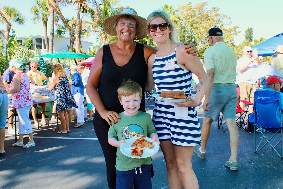 Margarita Lenk, Ari and Stephanie Weiner pick out their slices at the Longboat Harbour annual farewell pizza party on April 16.