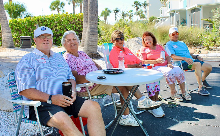 Ken and Penny Krol, Karen Talty, and Carol and John Bruno kick up their feet at the tropical-themed April 16 pizza party to bid farewell to Longboat Harbour residents departing for the summer.