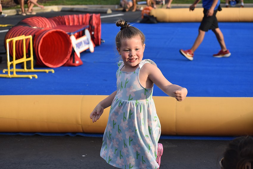Sarasota's Nora Pitts, 4, is in her element with music and dogs at Woofstock on Lakewood Main Street.