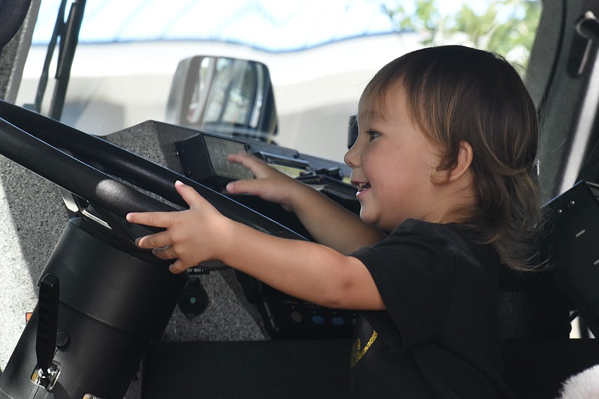 Seoyul Poma, 2, sits in the drivers' seat of a fire truck.