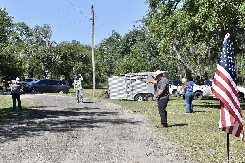 Members of the Florida Cracker Trail Association perform a ceremonial whip cracking salute.