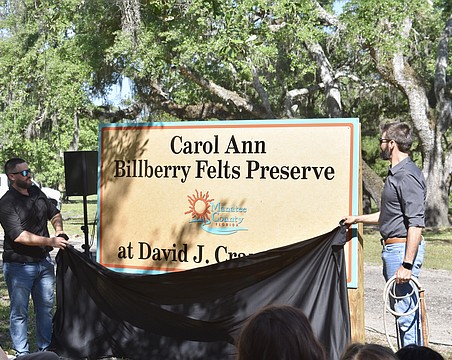 Carol Ann Felts' sons Kiel and Nicholas Felts unveil the new sign at David J. Crane Park.